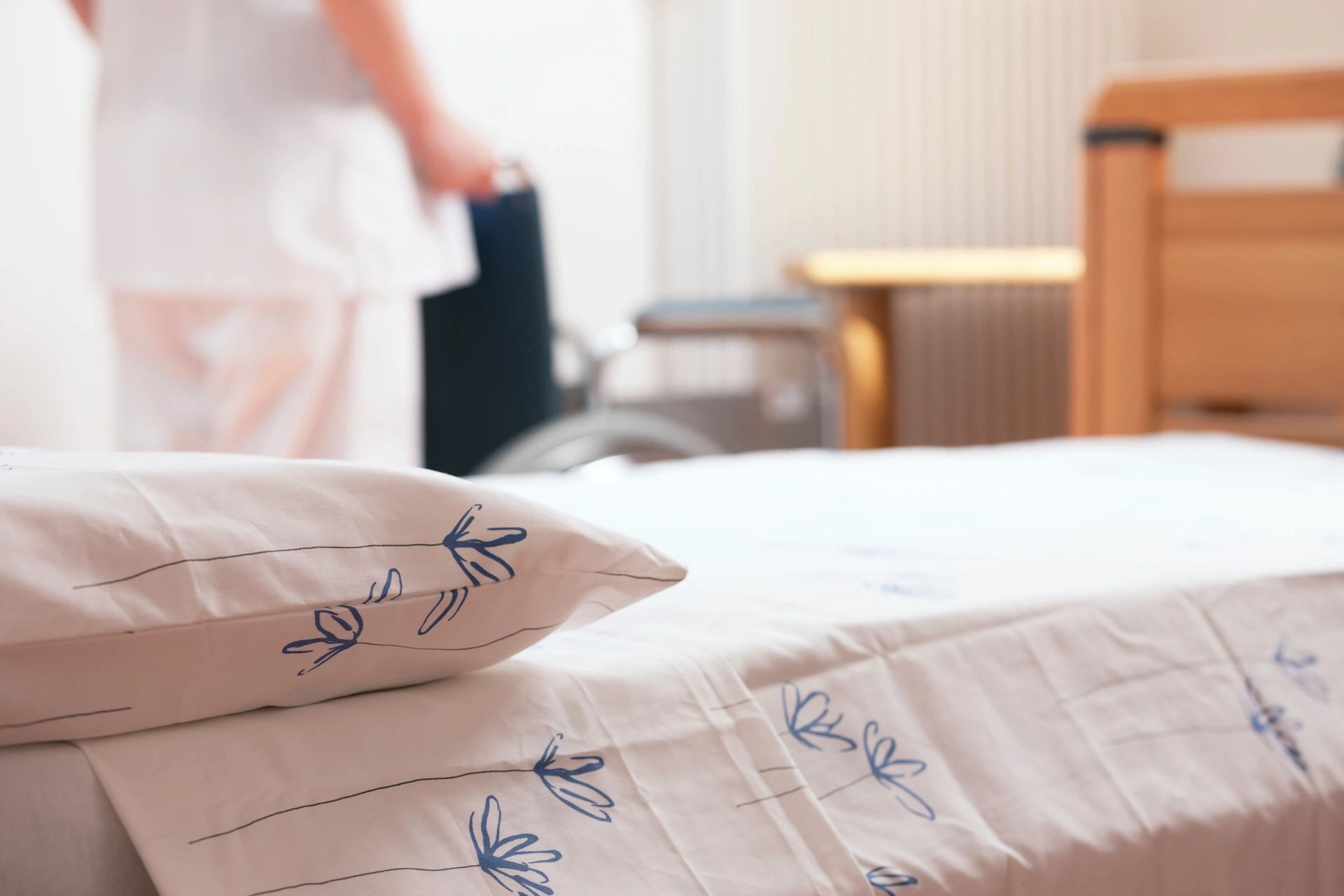 A person is cleaning the bed sheets on a hotel room.