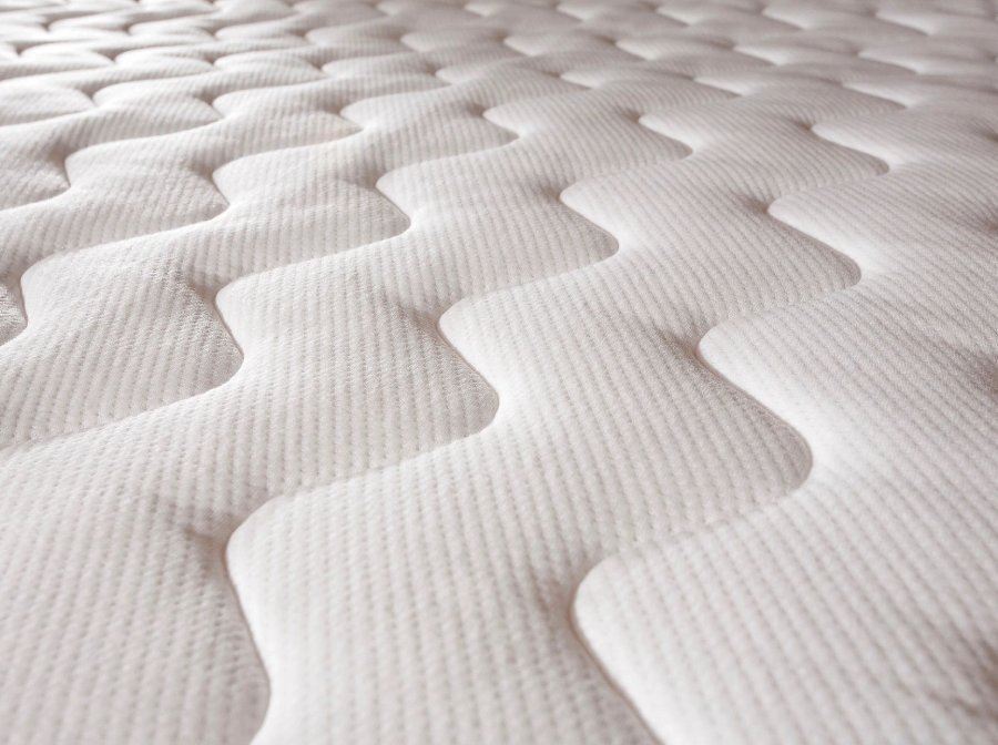 A close up of an unmade mattress with no sheets.