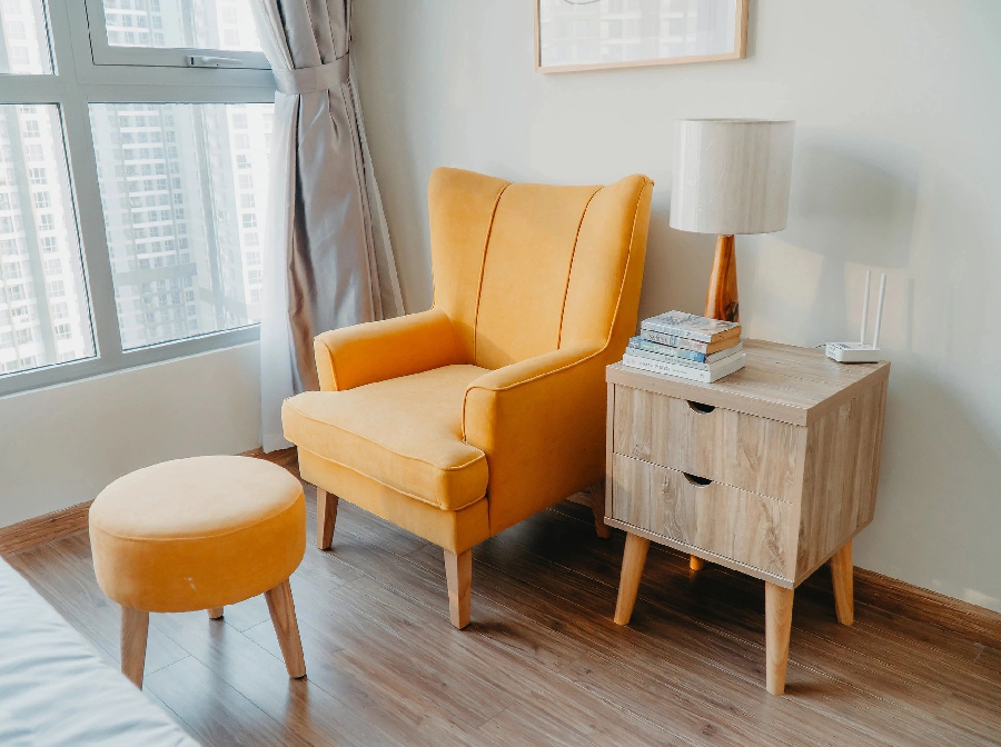 A yellow chair and table in the corner of a room.